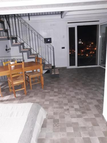 a living room with a staircase and a table and chairs at Via Pezza 100 in Ragusa