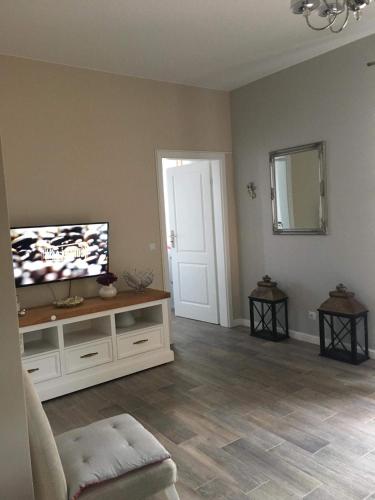 a living room with a flat screen tv on a white cabinet at Rubinowe Apartamenty in Sandomierz