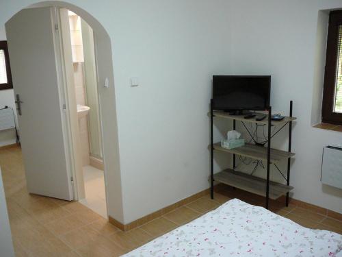 a room with a bedroom with a television and a door at Chaloupka v Podyjí - Podmolí in Podmolí