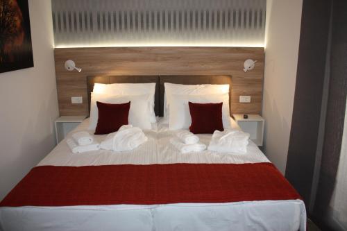 a bedroom with a large bed with red and white pillows at AURA Residence in Rovinj