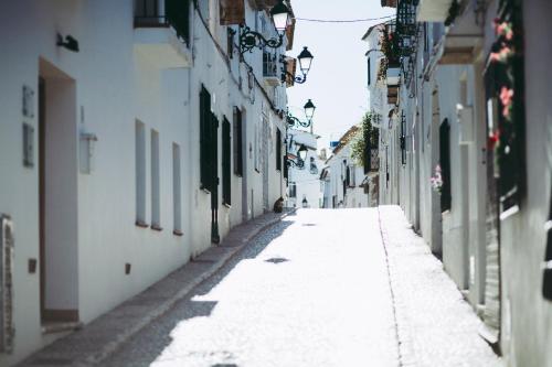 an empty street in an alley with white buildings at Gran H La Marina in Altea