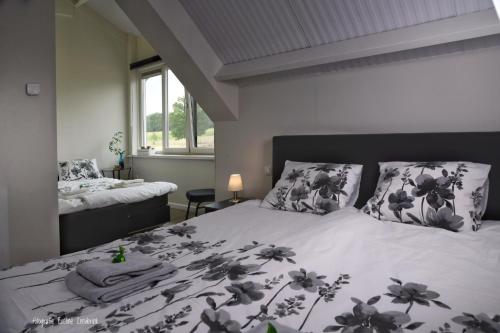 a bedroom with a bed with a black and white comforter at B&B Hof 't Sprakel in Haaksbergen