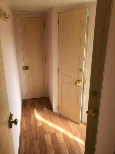 an empty room with two doors and a wooden floor at Angerhof Bischdorf in Bischdorf