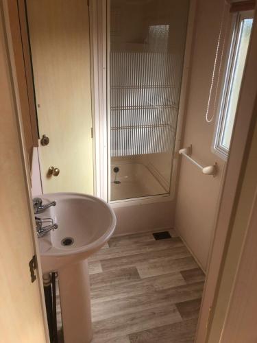 a white bathroom with a sink and a shower at Angerhof Bischdorf in Bischdorf