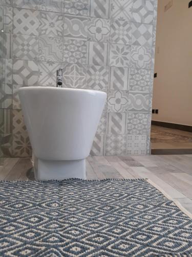 a white tub in a bathroom with a tile wall at Via Pezza 100 in Ragusa