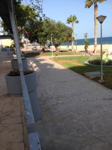 a sidewalk next to a beach with a palm tree at Residencial Aguilas Playa in Águilas