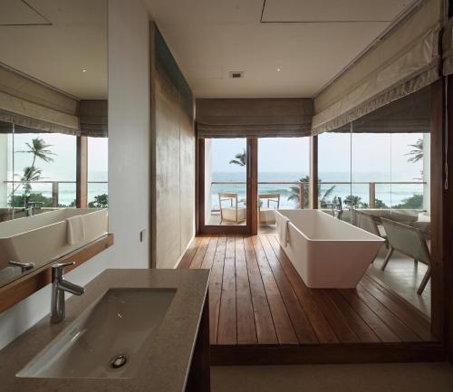 a bathroom with two sinks and a bath tub at Riff Hikkaduwa in Hikkaduwa