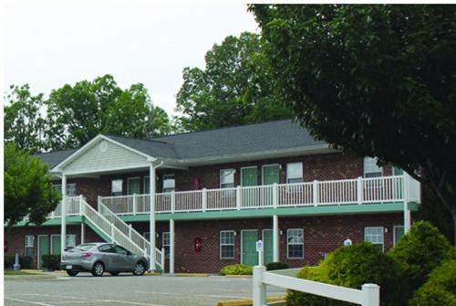 a red brick building with a car parked in front of it at Eastside Suites in Lynchburg