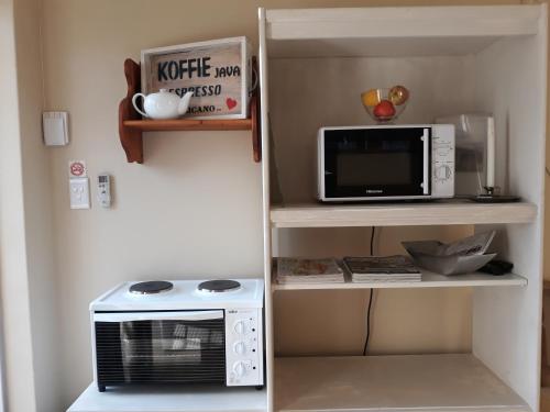 a microwave sitting on a shelf next to a microwave oven at Bergsig 2A in Clanwilliam