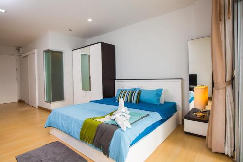 a bedroom with a large bed with blue sheets at At Seacondo-Studio-B26 in Klong Muang Beach