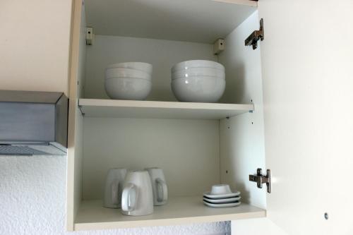 a cupboard with three bowls and plates in it at Apartment 003 Kassel Harleshausen in Kassel