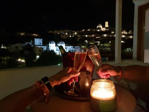 two people holding champagne glasses on a table with a candle at Gran H La Marina in Altea