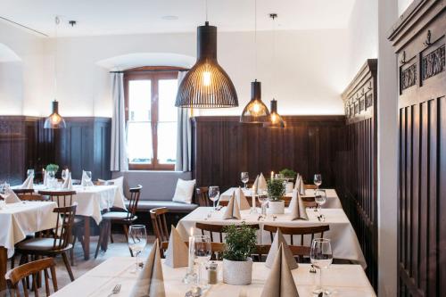 a restaurant with white tables and chairs and lights at Hotel Gasthof Lamm in Bregenz