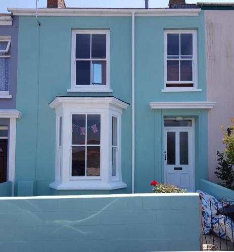 a blue house with a white window at Big, Beautiful, Cosy Falmouth House in Falmouth
