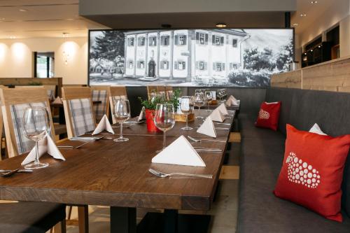 a dining room with a long wooden table with wine glasses at Hotel Gasthof Lamm in Bregenz