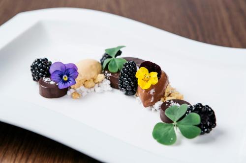 a plate with a dessert with chocolate and flowers on it at Hotel Gasthof Lamm in Bregenz