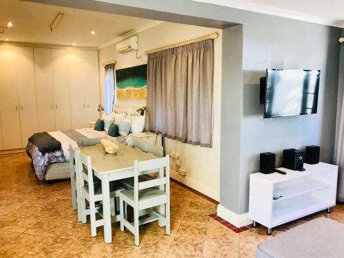 um quarto com uma cama e uma mesa e um quarto em Cosy Private Cottage em Port Elizabeth