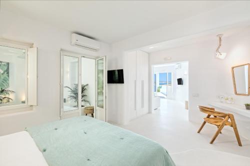 a white bedroom with a bed and a bathroom at Lilly Residence-All Sea View Suites, Adults Only in Naousa