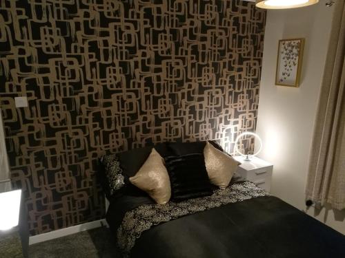um quarto com um sofá preto com uma parede estampada em The Hedgehogs em Inverness