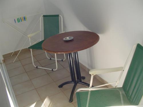 a small table and a chair in a room at Nina Rooms (apartments) in Artemida