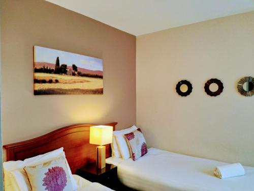 a hotel room with two beds and a picture on the wall at Thirteen On The Green - Eyre Square in Galway