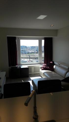 a room with two beds and a large window at Bella Vista First Class in Blankenberge
