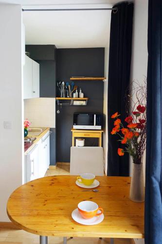 - une table en bois dans une cuisine avec un bol et une tasse dans l'établissement 1bis rue Capitaine Corhumel, à Nantes