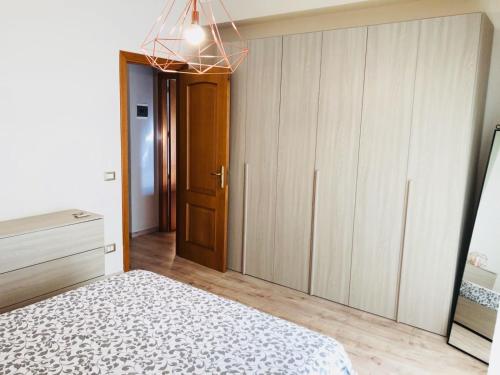 een slaapkamer met een bed, een dressoir en een kast bij SL Apartament in San Gregorio di Catania