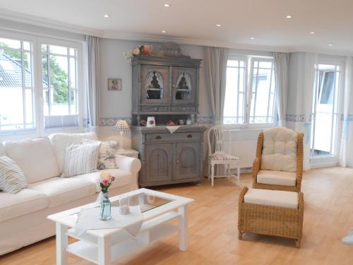 a living room with a white couch and a table at Haus Midsommer in Timmendorfer Strand