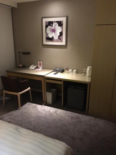 a hotel room with a desk with a flower on the wall at 麗馨商旅七賢館 in Kaohsiung