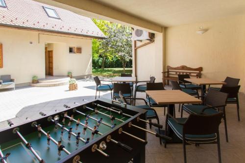 a patio with a pool table and tables and chairs at Villa Oliva Boutique Rooms Zamárdi in Zamárdi