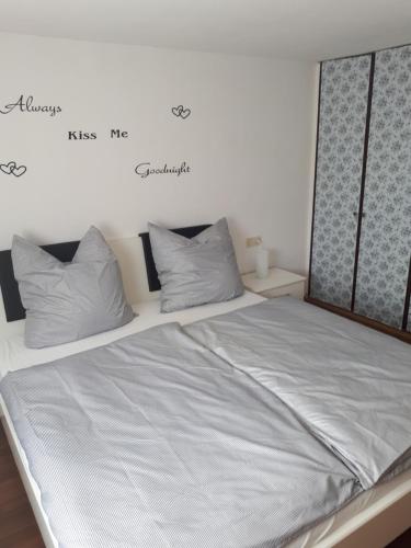 Ferienwohnung Frank في Merzalben: سرير عليه ملاءات ووسائد بيضاء