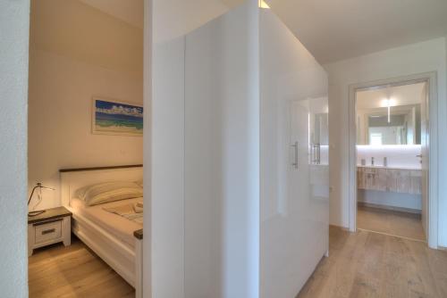 a white bedroom with a bed and a bathroom at BC Eleven - mit Zentralheizung in Senj