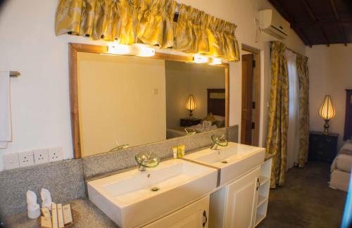 a bathroom with two sinks and a large mirror at Athulya Villas, Kandy in Kadugannawa