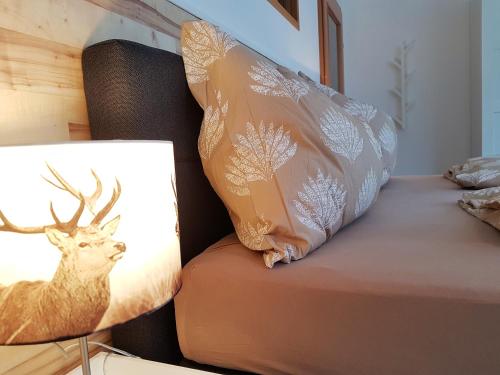 a bed with a pillow with a deer on it at Appartementhaus Zraunig in Flattach