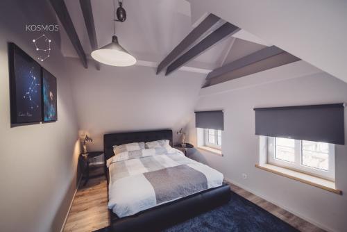 - une chambre avec un lit et 2 fenêtres dans l'établissement Kosmos 9 - Apartament Astro, à Toruń