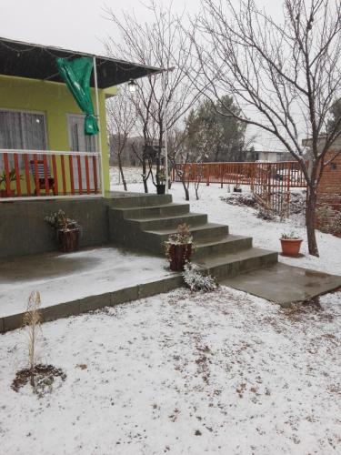 a house with snow on the ground in front of it at Atardecer Serrano in Huerta Grande