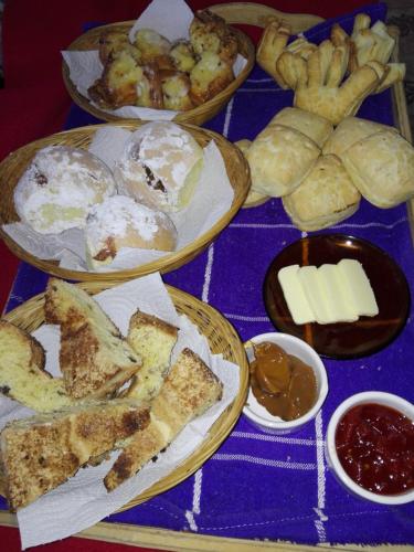 a table topped with plates of food and bread at Atardecer Serrano in Huerta Grande