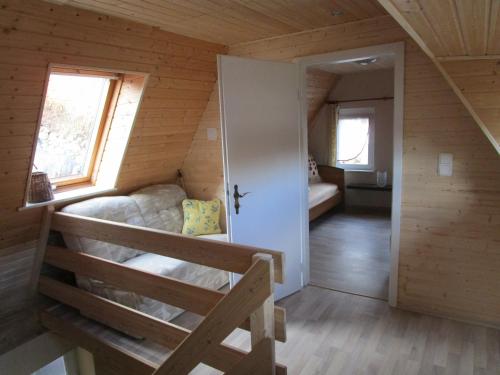 a small room with a bed in a wooden cabin at Mandauhaus mit Sauna in Hainewalde