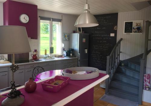 a kitchen with purple walls and a table with a lamp at Le Clos du Carpe Diem in Cambligneul