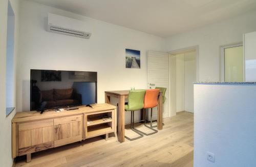 a living room with a tv and a desk with chairs at BC Eleven - mit Zentralheizung in Senj