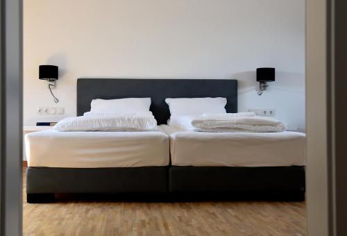 ノイシュタット・アン・デア・ヴァインシュトラーセにあるWeingut Nickelのベッドルーム1室(白いシーツと枕のベッド2台付)