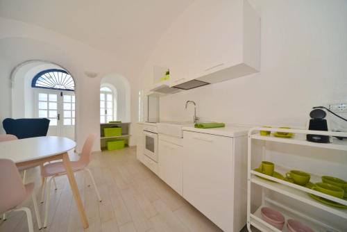 a white kitchen with a table and a dining room at Bistrot del mare in Santo Stefano al Mare