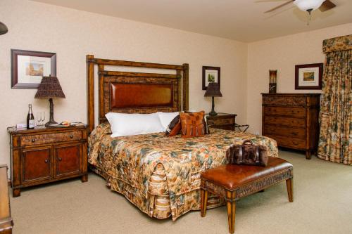a bedroom with a large bed and a dresser and a chair at Heather Lodge in Minden