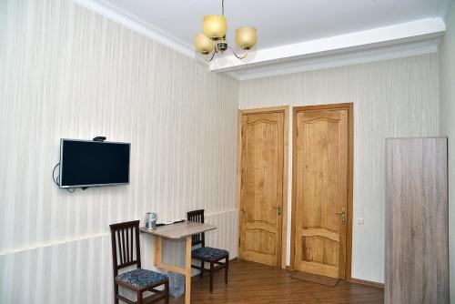 a room with a table and a tv on a wall at Center Villa Kutaisi in Kutaisi