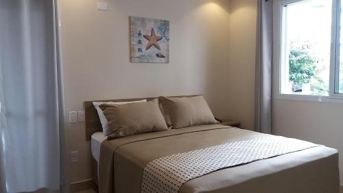 a bed in a room with a window at Pousada Ilha das Conchas in Guarujá