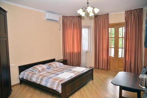 a bedroom with a bed and a table in it at Center Villa Kutaisi in Kutaisi