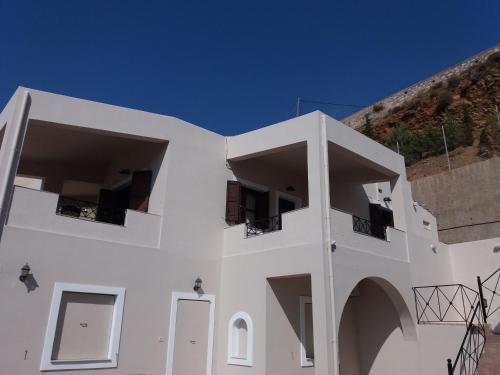 a white building with two balconies on top of it at George in Myrties