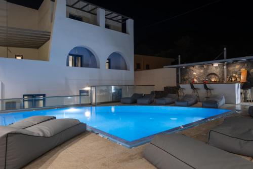 a pool in the middle of a house at night at Tristhenia in Perissa