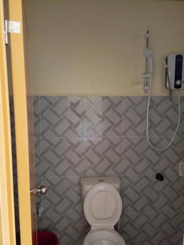 a bathroom with a toilet and a shower at Alona KatChaJo Inn in Panglao Island